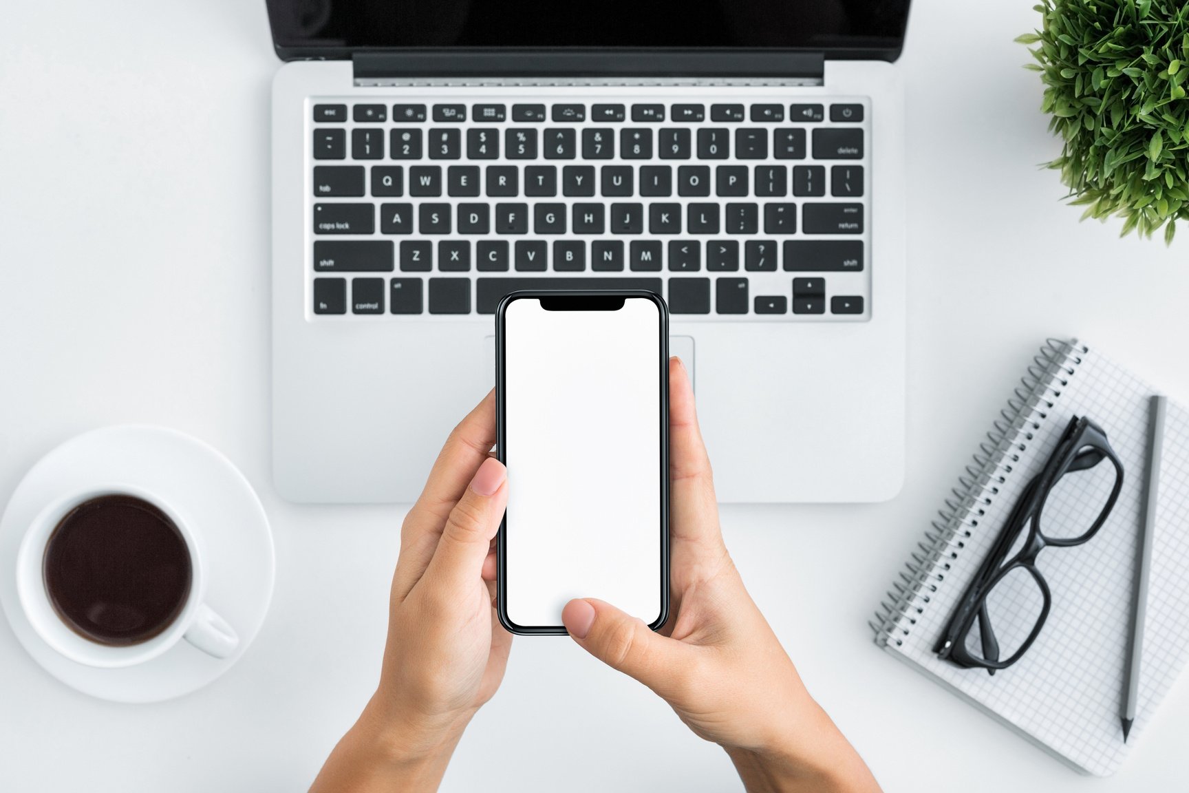 Hand using smartphone on white wooden background